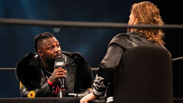 Swerve Strickland talks to Hangman Page during a promo segment